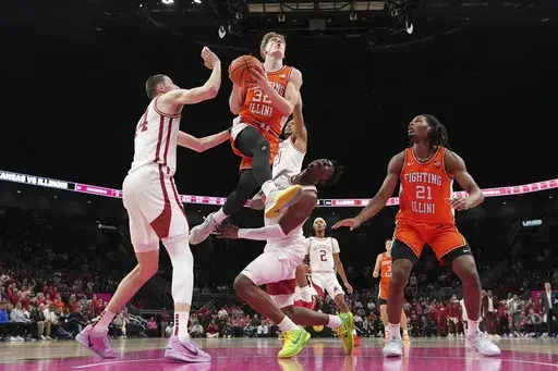 Illinois guard Kasparas Jakucionis (32) gets past Arkansas forwards Zvonimir Ivisic, left, and Adou Thiero, center, to put up a shot during the second half of an NCAA college basketball game, Thursday, Nov. 28, 2024, in Kansas City, Mo. (AP Photo/Charlie Riedel)
