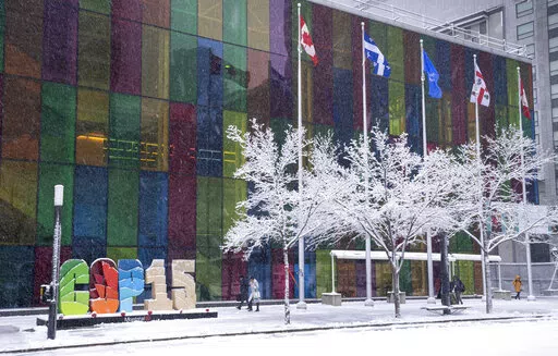 Delegates arrive at the convention centre at the COP15 UN conference on biodiversity during a snowfall in Montreal, Friday, Dec. 16, 2022. (Paul Chiasson /The Canadian Press via AP)