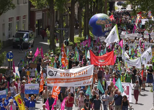 Climate activists and others hold banners and signs as they march during a demonstration ahead of a G-7 meeting in Munich, Germany, June 25, 2022. At this year's G-7 summit, Germany will push its plan for countries to join together in a ‘climate club' to tackle global warming.  (AP Photo/Matthias Schrader, File)