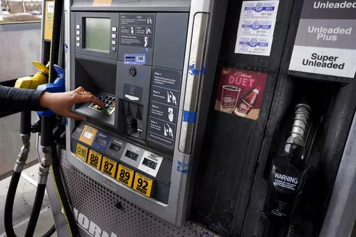 A woman presses button to fill up a gas tank at a gas station in East Dundee, Ill., Saturday, March 19, 2022.  The Conference Board, a business research group, said Tuesday, April 26,  that its consumer confidence index — which takes into account consumers’ assessment of current conditions and their outlook for the future — edged down to 107.3 in April from 107.6 in March. (AP Photo/Nam Y. Huh, File)