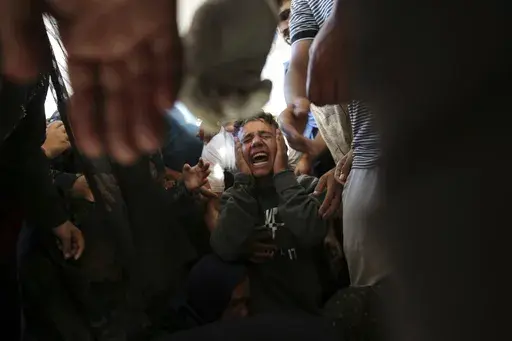 Palestinians mourn their relatives killed in the Israeli bombardment of the Gaza Strip at a hospital morgue in Khan Younis, southern Gaza Strip, Monday, June 24, 2024. (AP Photo/Jehad Alshrafi)