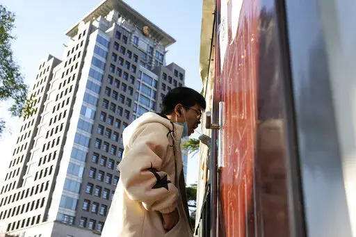 A man gets swabbed for COVID test near a building of the Peking University in Beijing, Wednesday, Nov. 16, 2022. Chinese authorities locked down the major university in Beijing on Wednesday after finding one COVID-19 case as they stick to a "zero-COVID" approach despite growing public discontent. (AP Photo/Ng Han Guan)