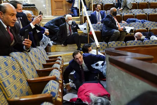 Members of Congress shelter in the House gallery as rioters try to break into the House Chamber at the U.S. Capitol on Jan. 6, 2021, in Washington. (AP Photo/Andrew Harnik, File)