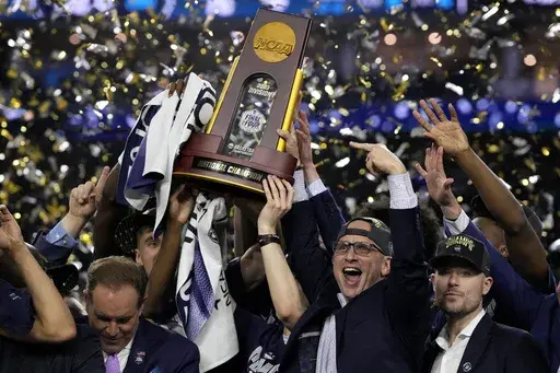 Connecticut head coach Dan Hurley celebrates with the trophy after their win against San Diego State in the men's national championship college basketball game in the NCAA Tournament on Monday, April 3, 2023, in Houston. (AP Photo/David J. Phillip, File)