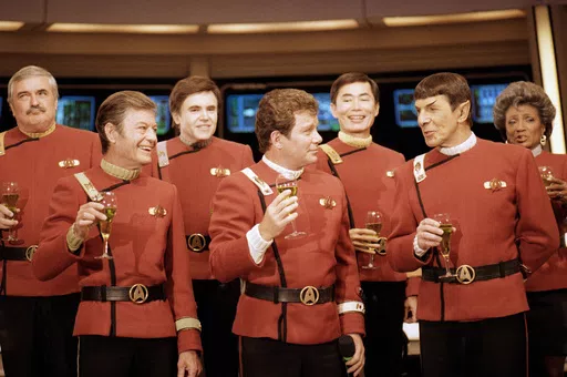 Members of the "Star Trek" crew, from left, James Doohan, DeForest Kelley, Walter Koenig, William Shatner, George Takei, Leonard Nimoy and Nichelle Nichols, toast the newest "Star Trek" film during a news conference at Paramount Studios in Los Angeles, Dec. 28, 1988. (AP Photo/Bob Galbraith, File)