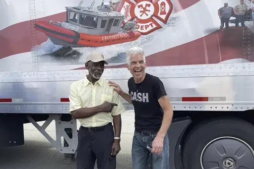 Artist Kevin Kresse, who sculpted a statue of Johnny Cash destined for the U.S. Capitol, laughs with Shimpfort Hardney, who will be driving the sculpture to Washington, outside the Arkansas Capitol in Little Rock, Ark., Thursday, Sept. 5, 2024. (AP Photo/Andrew DeMillo)