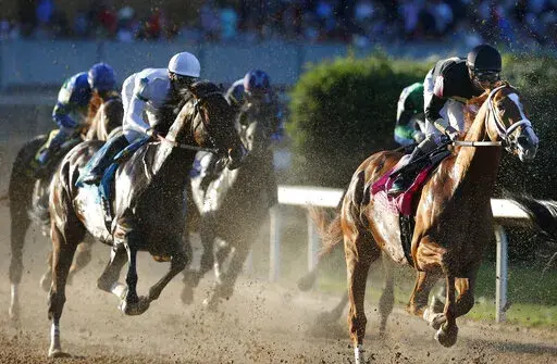 Cyberknife, ridden by jockey Florent Geroux, heads through the first turn on the way to winning the Arkansas Derby horse race Saturday, April 2, 2022, at Oaklawn in Hot Springs, Ark. (Tommy Metthe/The Arkansas Democrat-Gazette via AP)