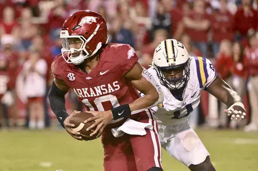 Arkansas quarterback Taylen Green (10) tries to get away from LSU defensive end Paris Shand (0) during the second half of an NCAA college football game Saturday, Oct. 19, 2024, in Fayetteville, Ark. (AP Photo/Michael Woods)
