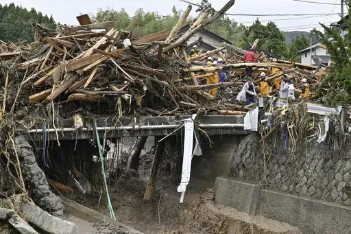 Rescuers search where houses were swept away along a river in Wajima, Japan, Sunday, Sept. 22, 2024, following heavy rain in central Japan's Noto peninsula area, where a devastating earthquake took place on Jan. 1. (Muneyuki Tomari/Kyodo News via AP)