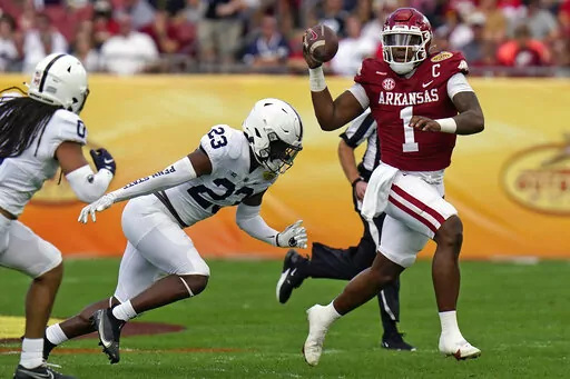 Arkansas quarterback KJ Jefferson (1) eludes Penn State linebacker Curtis Jacobs (23) during the first half of the Outback Bowl NCAA college football game Saturday, Jan. 1, 2022, in Tampa, Fla. (AP Photo/Chris O'Meara)