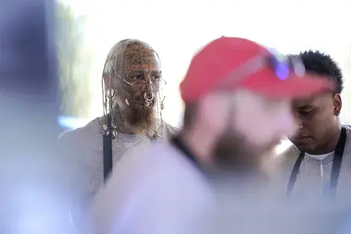 Cyrus Collins, left, an aspiring Minneapolis police officer, works his part-time job as a cook at The Blue Barn during the Minnesota State Fair, on Sept. 3, 2022, in Falcon Heights, Minn. Collins was among a handful of people at a recent Minneapolis Police Department recruiting session as the department seeks to rebuild its ranks following the departure of hundreds of officers in the wake of George Floyd's killing. (AP Photo/Abbie Parr)