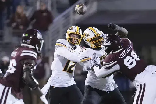 Missouri quarterback Brady Cook (12) passes the ball under Mississippi State defensive pressure during the second half of an NCAA college football game, Saturday, Nov. 23, 2024, in Starkville, Miss. (AP Photo/Rogelio V. Solis)
