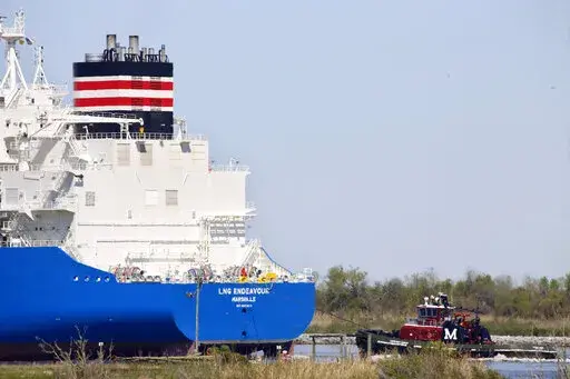 A tugboat helps guide a French ship, known as the LNG Endeavor, through Calcasieu Lake near Hackberry, La., on March 31, 2022. Russia’s war against Ukraine shattered its relations with Europe, which soon lost most of the natural gas that Moscow had long provided. Now, as winter nears, European nations have backed a short-term fix set to begin before the end of 2022 that has raised alarms among scientists who fear the long term consequences for the climate. (AP Photo/Martha Irvine, File)