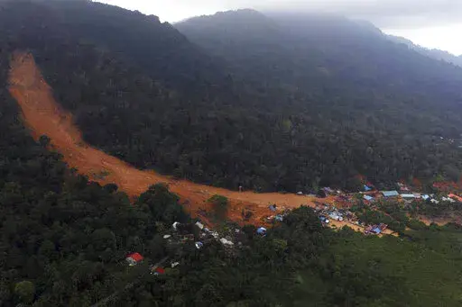 This aerial photo released by Indonesia's National Disaster Management Agency (BNPB) on Wednesday, March 8, 2023, shows a village affected by landslide on Serasan Island, Natuna regency, Indonesia. Rescuers in the remote Indonesian islands are searching for people who are believed to be buried in their houses by landslides that tore through villages after torrential rains and killed a number of people. (BNPB via AP)