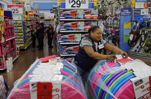 Balo Balogun labels items in preparation for a holiday sale at a Walmart Supercenter, Wednesday, Nov. 27, 2019, in Las Vegas.  Walmart plans to hire 40,000 U.S. workers for the holidays, a majority of them seasonal workers. The move announced Wednesday, Sept. 21, 2022,  comes as the nation’s largest retailer and largest private employer said it’s in a stronger staffing position heading into the holidays than last year.   (AP Photo/John Locher, File)