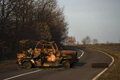 A burned Ukranian army vehicle stands on a street leading to the airport of the city of Mykolaiv, Ukraine, Friday, 25, 2022.(AP Photo/Petros Giannakouris)