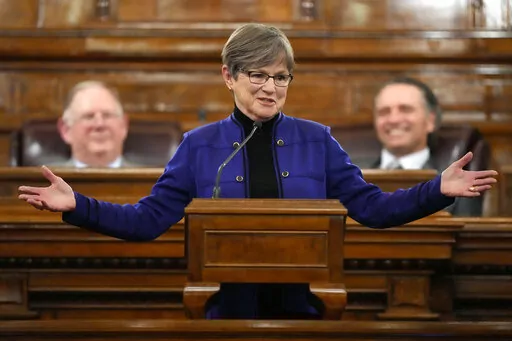 Flanked by Speaker of the House Daniel Hawkins, left, and Senate President Ty Masterson, Kansas Gov. Laura Kelly delivers her State of the State address, Tuesday, Jan. 24, 2023, in Topeka, Kan. (AP Photo/Charlie Riedel)