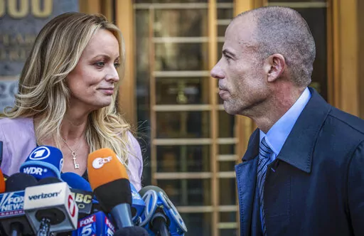 Adult film actress Stormy Daniels, left, stands with her lawyer Michael Avenatti during a news conference outside federal court in New York, April 16, 2018. Daniels, the porn star who catapulted Avenatti to fame, will get a starring role in a New York courtroom when prosecutors try to prove the California lawyer cheated her of $300,000 in book proceeds. (AP Photo/Mary Altaffer, File)