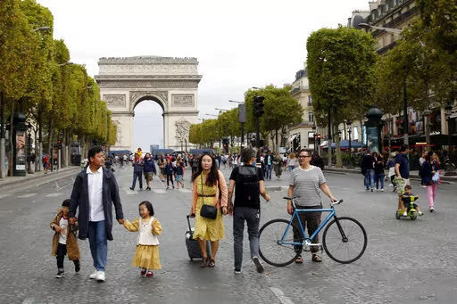 People walk on the champs Elysees avenue during the "day without cars", with the Arc de Triomphe in background, in Paris, on Sept. 22, 2019. Conservatives and conspiracy theorists are increasingly convinced the concept of a “15-minute city” is the latest nefarious plot to curtail individual freedoms. But urban experts and city officials say the design principle -- recently embraced by cities including Oxford, England, Paris, and Cleveland, Ohio -- is simply about building more compact, walka