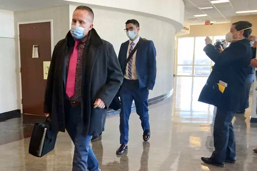 Brett Hankison, left, exits the courtroom after the first day of jury selection in his trial on Tuesday, Feb. 8, 2022, in Louisville, Ky. Hankison is on trial for allegedly firing shots into the apartment next door to Breonna Taylor's the night she was killed. (AP Photo/Dylan Lovan)
