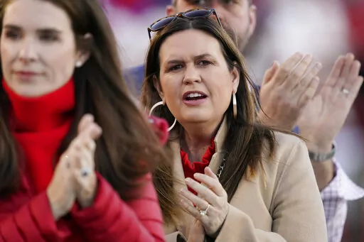 Arkansas Gov.-elect Sarah Huckabee Sanders, center, applauds following the playing of the national anthem before the Liberty Bowl NCAA college football game, Wednesday, Dec. 28, 2022, in Memphis, Tenn. Sanders named Jacob Oliva, a top Florida schools official, as her pick to lead the state's education agency on on Thursday, Dec. 29, 2022, the latest signal of the direction of the Republican's nascent administration. (AP Photo/Rogelio V. Solis, File)