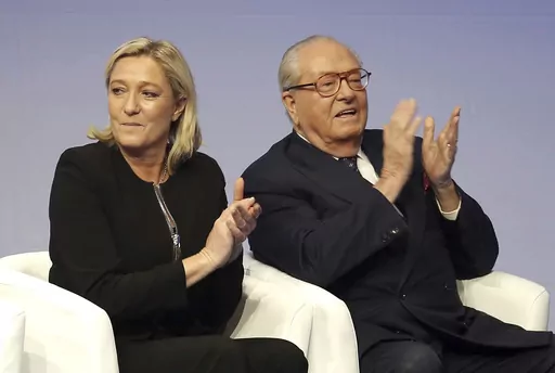 In this Saturday Nov. 29, 2014 file photo, French far-right Front National leader Marine Le Pen and her father Jean-Marie Le Pen applaud in Lyon, central France. A march against antisemitism this weekend in Paris, with the prime minister, government members, political parties and citizens in attendance, is fraught with discord over the planned presence of far-right leader Marine Le Pen. Her father and party founder Jean-Marie Le Pen has been convicted numerous times of antisemitism and racism. (