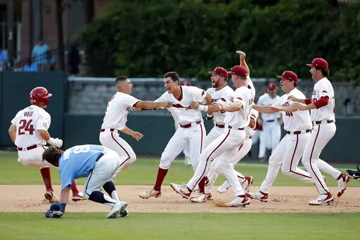 Arkansas players celebrate their win over North Carolina following an NCAA college super regional baseball game in Chapel Hill, N.C., Sunday, June 12, 2022. (AP Photo/Karl B DeBlaker)