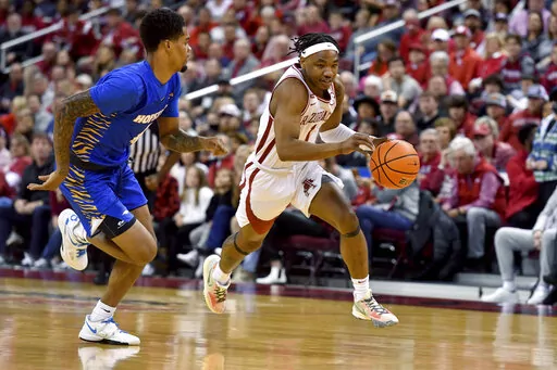 Arkansas guard JD Notae (1) tries to get past Hofstra guard Aaron Estrada (4) on a fast break during the first half of an NCAA college basketball game, Saturday, Dec. 18, 2021, in Little Rock, Ark. (AP Photo/Michael Woods)