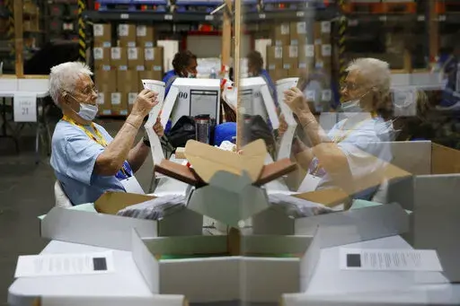 Election workers process mail-in ballots during a nearly all-mail primary election in Las Vegas, June 9, 202. For the first time in decades, hand-counting will be used in parts of Nevada on election day. Nationwide proponents of hand-counting have described the old-school method in broad terms as a way to address distrust in elections. (AP Photo/John Locher, File)
