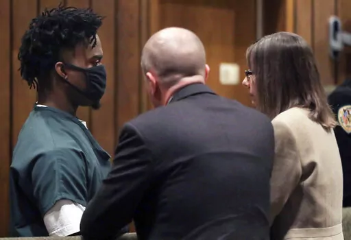 Ezekiel Kelly, left, who has been charged with killing three people and wounding three others on Sept. 7 as he drove around Memphis, livestreaming some of his activities on social media, talks to his defense attorneys during his trial, Tuesday, Oct. 18, 2022, in Memphis. (Patrick Lantrip/Daily Memphian via AP)