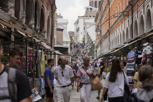 FILE -Tourists walk in a crowded street in Venice, Italy, Wednesday, Sept. 13, 2023. Venice on Saturday, Dec. 30, 2023 announced new limits on the size of tourist groups in another measure aimed at reducing the pressure of mass tourism on the famed canal city. Starting in June, groups will be limited to 25 people. (AP Photo/Luca Bruno, File)