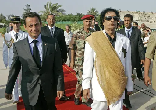 Libyan leader Moammar Gadhafi, right, welcomes French President Nicolas Sarkozy at the Bab Azizia Palace in Tripoli, July 25, 2007. (AP Photo/Michel Euler, File)