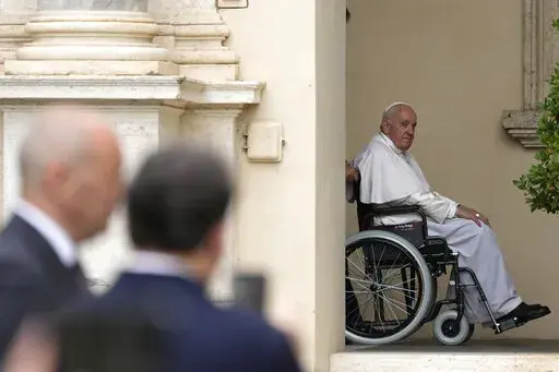Pope Francis arrives on a wheelchair for an audience with children in the San Damaso courtyard at the Vatican, Saturday, June 4, 2022. Pope Francis added fuel to rumors about the future of his pontificate on Saturday by announcing he would visit the central Italian city of L'Aquila in August for a feast initiated by Pope Celestine V, one of the few pontiffs who resigned before Pope Benedict XVI stepped down in 2013. (AP Photo/Alessandra Tarantino, File)