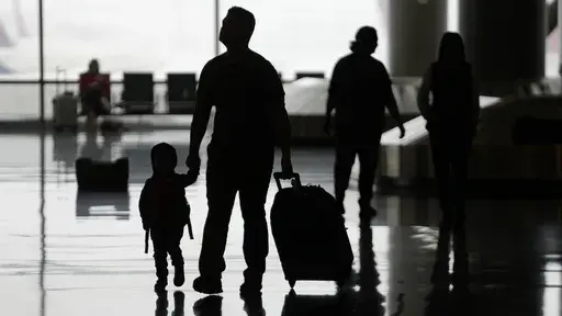 People travel through Salt Lake City International Airport on Wednesday, Feb. 22, 2023, in Salt Lake City. When discussing a multigenerational family trip, have a plan to avoid arguments around topics like when to travel, where you’ll go, what you’ll do there or how you’ll split bills. With groups, it’s often best for each family unit to book their lodging and transportation. (AP Photo/Rick Bowmer, File)