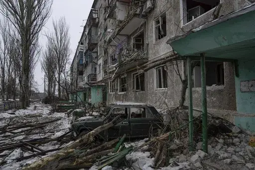 A destroyed car is seen in front of a residential building which was heavily bombed by Russian forces, in the frontline city of Vuhledar, Ukraine, Feb. 25, 2023. (AP Photo/Evgeniy Maloletka, File)