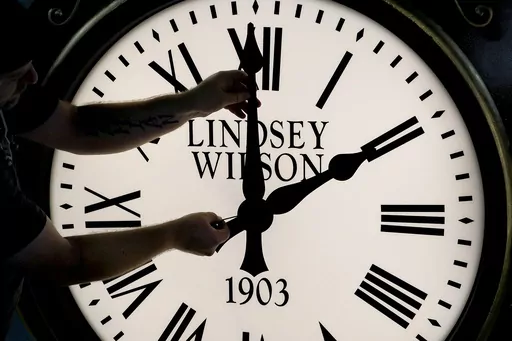 Dan LaMoore adjusts the hands on a Seth Thomas Post Clock at Electric Time Company, Oct. 23, 2020, in Medfield, Mass. Standard time comes to an end in most parts of the United States this weekend. You’ll lose an hour of sleep for one night but gain more daylight in the evening in the months ahead. (AP Photo/Elise Amendola, File)