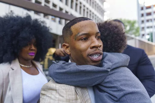 Rapper Tory Lanez, 30, walks out of the courthouse while holding his 5-year-old son Kai'Lon, Tuesday, Dec. 13, 2022, in Los Angeles. Megan Thee Stallion took the stand Tuesday and told jurors that Lanez fired five shots at her feet, yelled at her to dance and wounded her as she tried to walk away from him in the Hollywood Hills more than two years ago. The Canadian rapper has pleaded not guilty to discharging a firearm with gross negligence, assault with a semiautomatic firearm and carrying a lo
