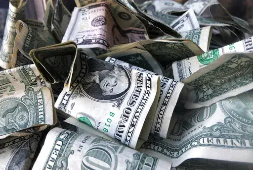 A box filled with dollar bills is shown in New York, Wednesday, April 3, 2019. Even though your tax refund can feel like a gift from the government, the best use of those funds is not always apparent. (AP Photo/Mark Lennihan, File)