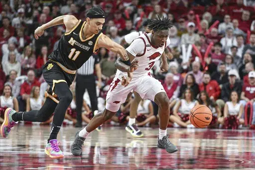 Missouri guard Trent Pierce (11) and Arkansas forward Adou Thiero (3) go after a loose ball during the second half of an NCAA college basketball game Saturday, Feb. 22, 2025, in Fayetteville, Ark. (AP Photo/Michael Woods)