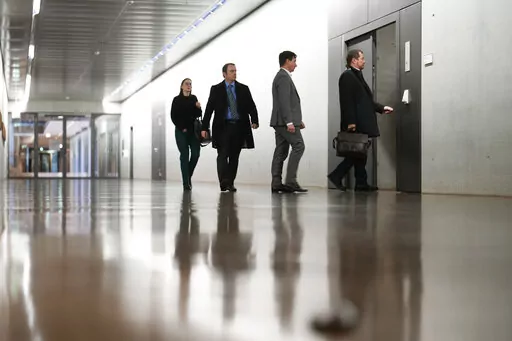 German lawmakers and officials enter a secure room at the basement of the German Parliament, for a briefing by intelligence officials on the alleged coup plot by far-right extremists that authorities uncovered last week, in Berlin, Germany, Monday, Dec. 12, 2022. Prosecutors say some of those detained last week had plans to enter the German parliament, or Bundestag, with weapons. (AP Photo/Markus Schreiber)
