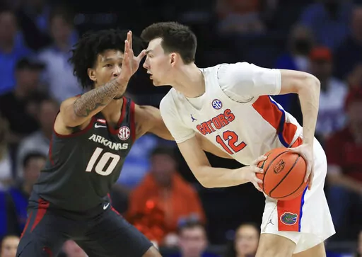 Arkansas forward Jaylin Williams (10) defends against Florida forward Colin Castleton (12) during the first half of an NCAA college basketball game Tuesday, Feb. 22, 2022, in Gainesville, Fla. (AP Photo/Matt Stamey)