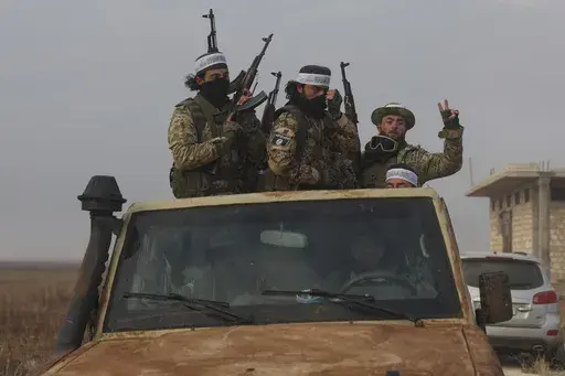 Syrian opposition fighters ride in a truck in Talhiya, Idlib countryside, Syria, Friday, Nov. 29, 2024. (AP Photo/Ghaith Alsayed)