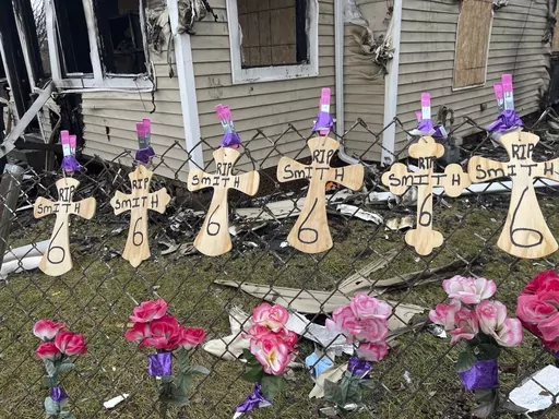 Six markers are placed in front of a burned out home in South Bend, Ind., Sunday, Jan. 28, 2024. An 11-year-old girl who was hospitalized for burns following a northern Indiana house fire has died, bringing the fire's death toll to six children, all of them siblings, authorities said Monday. (Camille Sarabia/South Bend Tribune via AP)