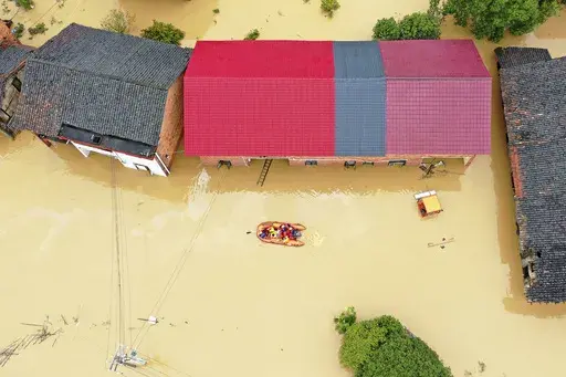 Rescuers use a dinghy boat to evacuate villagers trapped by floodwaters in Jingtang village, Zixing city, in southern China's Hunan province, on July 28, 2024. (Chinatopix via AP, File)