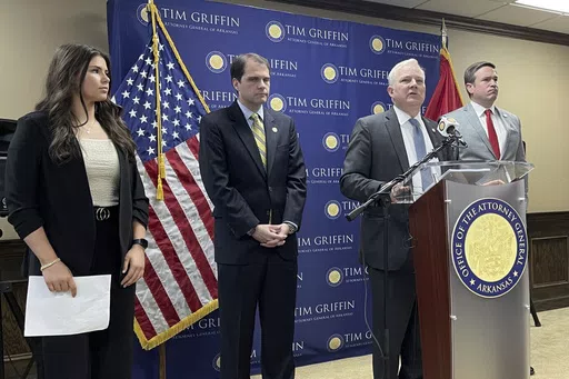 Arkansas Attorney General Tim Griffin speaks at a news conference at the attorney general's office in Little Rock, Ark., Tuesday, May 7, 2024, about a lawsuit challenging a new regulation aimed at protecting the rights of transgender students in schools. Missouri Attorney General Andrew Bailey, right, and Arkansas Solicitor General Nicholas Bronni and high school athlete Amelia Ford, left, listen. (AP Photo/Andrew DeMillo)