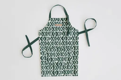 This image provided by Minted shows an apron featuring the fabric print creativity of one of Minted's community of independent artists, Luz Alliat. This adult's apron's pattern is called Outdoors. Aprons can be personalized with a custom foil-pressed leather name tag. (Minted via AP)
