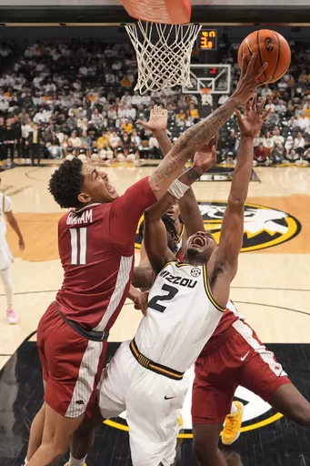 Arkansas' Jalen Graham (11) knocks the ball away from Missouri's Tamar Bates (2) during the first half of an NCAA college basketball game Wednesday, Jan. 31, 2024, in Columbia, Mo. (AP Photo/Jeff Roberson)