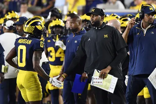 Michigan head coach Sherrone Moore, second from right, congratulates wide receiver Semaj Morgan (0) who comes off the field in the second half of an NCAA college football game against Fresno State, Saturday, Aug. 31, 2024, in Ann Arbor, Mich. (AP Photo/Jose Juarez)
