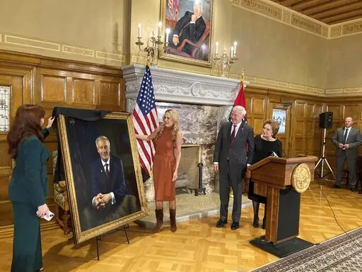 CORRECTS NAME TO SARAH WENGEL, NOT SUSAN WENGEL -Arkansas Gov. Asa Hutchinson and first lady Susan Hutchinson look on as their granddaughter, Jaella Wengel, left, and daughter, Sarah Wengel, center, unveil the governor's official portrait on Tuesday, Jan. 3, 2023, at the state Capitol in Little Rock, Ark. Hutchinson will leave office on Jan. 10 after serving eight years as governor. (AP Photo/Andrew DeMillo)