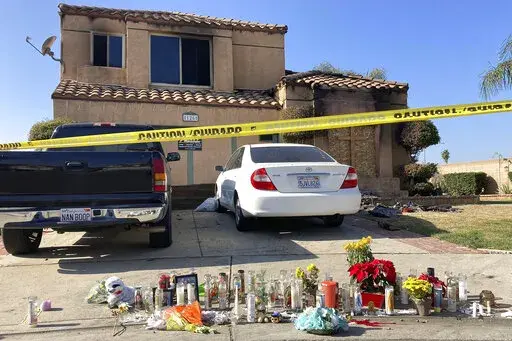 Dozens of candles sit placed on the sidewalk along with bouquets of flowers and stuffed animals outside a charred home in Riverside, Calif., Wednesday, Nov. 30, 2022. Authorities say that a Virginia sheriff's deputy who police say traveled to California to kill several family members of a 15-year-old girl he tried to sexually extort online killed himself with a government-issued firearm. (AP Photo/Amy Taxin, File)